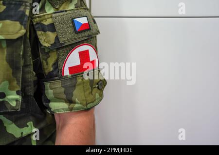 Brno, Tchéquie - 08 octobre 2021 : croix rouge et drapeau tchèque sur une manche moderne de soldat médique, gros plan Banque D'Images