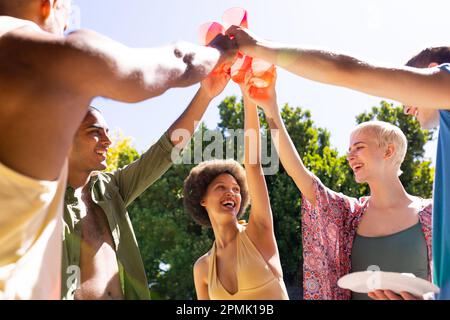 Joyeux groupe d'amis divers faisant un toast dans le jardin Banque D'Images