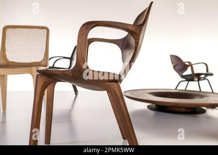 Chaises en bois au design moderne, exposées dans une salle d'exposition avec fond blanc rétroéclairé Banque D'Images