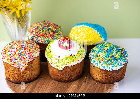 Gâteau de Pâques ukrainien traditionnel Kulich. Pain de Pâques chrétien orthodoxe ou gâteau de Pâques avec glaçage, œufs de Pâques et brindilles de saule sur fond bleu Banque D'Images