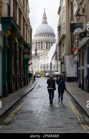 Londres, Royaume-Uni - 18 mars 2023 ; deux personnes avec un parapluie marchant dans un allié à la cathédrale St Paul Banque D'Images