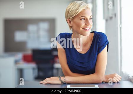Profitez de la vue depuis le sommet. une jeune femme d'affaires travaillant sur sa tablette au bureau. Banque D'Images