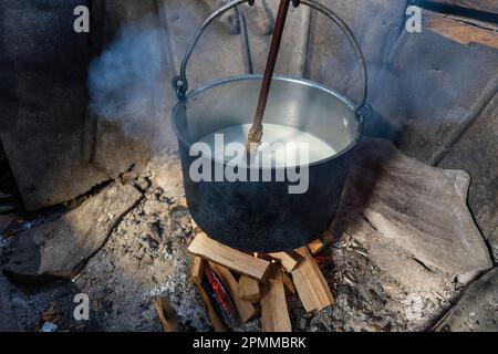 Fabrication de fromage de brebis biologique dans une usine de fromage Carpates de montagne en bois avec un chou-fleur fumé bouillante et du lait au feu ouvert, Ukraine occidentale, Europ Banque D'Images