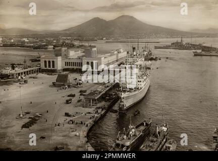 Rome, Italie mai 1951 : photo d'époque de la gare maritime de Naples avec des navires amarrés et une vue imprenable sur le Vésuve en arrière-plan. Banque D'Images