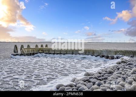 Den Oever, pays-Bas - 10 février 2021. Accumulation de glace sur les jetées de l'Afsluitdijk dans l'Ijsselmeer, Den Oever, Hollande. Banque D'Images