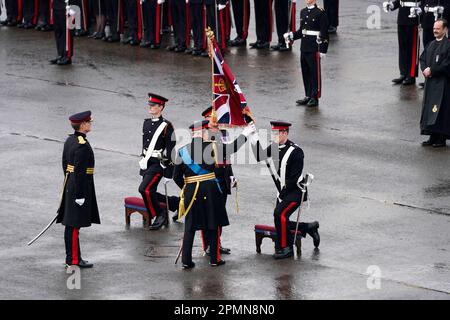 Le roi Charles III touche les nouvelles couleurs lors de la Parade Sovereign de 200th à l'Académie militaire royale de Sandhurst (RMA) à Camberley, Surrey. Date de la photo: Vendredi 14 avril 2023. Banque D'Images