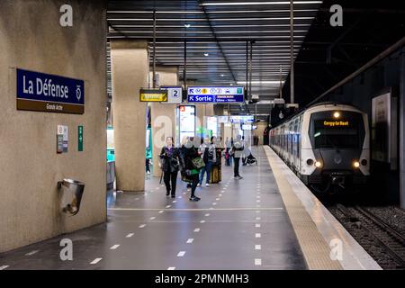 Les passagers se préparent à monter à bord du train arrivant à la plate-forme de la station de métro la Défense sur la ligne A du réseau de transports en commun RER. Banque D'Images