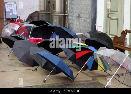 Rostock, Allemagne. 14th avril 2023. Des parasols étirés sont installés dans la zone d'entrée de St. L'église de Marie, où ils sont censés sécher. La pluie continue détermine le temps dans le nord. Credit: Bernd Wüstneck/dpa/Alay Live News Banque D'Images