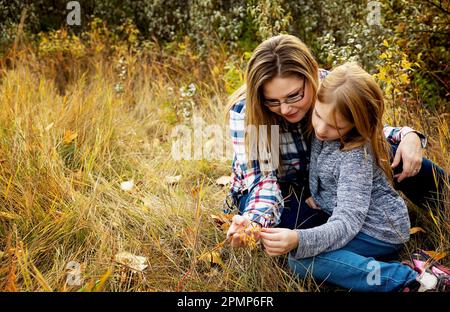 Portrait extérieur d'une mère passant du temps avec sa fille dans un parc en automne; Edmonton, Alberta, Canada Banque D'Images