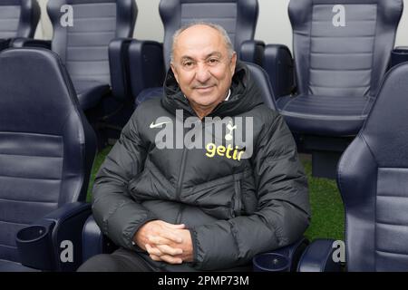 Ossie Ardiles portant la veste Tottenham Hotspur Nike et Getir assis dans la dugout Tottenham Hotspur Stadium souriant à la caméra avec les mains pliées. Banque D'Images