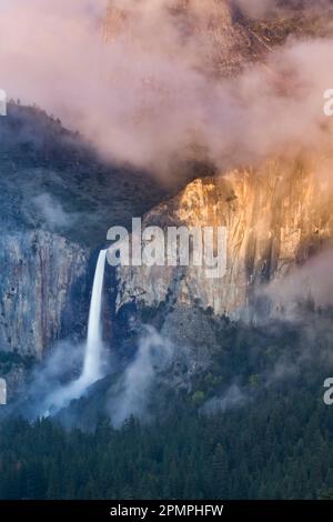 La lumière du soleil illumine les falaises au-dessus de Bridalveil Fall dans le parc national de Yosemite, Californie, États-Unis ; Californie, États-Unis d'Amérique Banque D'Images