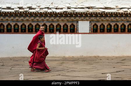 Deux jeunes moines marchant à travers un monastère ; Paro Valley, Bhoutan Banque D'Images