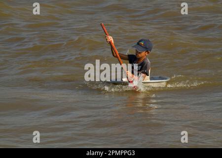 Enfant navigue sur un bateau sur le Grand Lac ou Tonle SAP ; Tonle SAP, Cambodge Banque D'Images