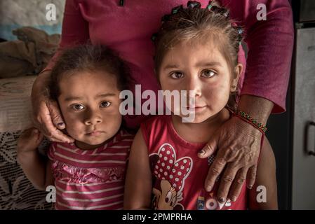 Femme debout avec ses mains embrassant deux jeunes filles ; Ejido Hidalgo, San Luis, Mexique Banque D'Images