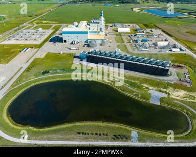 Vue aérienne d'une centrale électrique avec tour de refroidissement au premier plan et ciel bleu, à l'est de Calgary, Alberta ; Alberta, Canada Banque D'Images