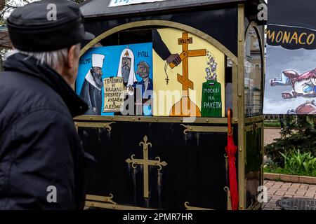 Un ukrainien regarde des images qui illustrent le patriarcat russe comme outil de guerre de Poutine lors des célébrations du Vendredi Saint devant Kiev Pechersk Lavra, la capitale de l'Ukraine le vendredi orthodoxe de Pâques - 14 avril 2023. La plupart des Ukrainiens sont des chrétiens orthodoxes ou des chrétiens catholiques grecs, tous deux observent le rite oriental de Pâques. Kiev reste relativement pacifique alors que l'invasion russe se poursuit et que l'Ukraine se prépare à une contre-offensive printanière pour reprendre les terres ukrainiennes occupées par la Russie. (Photo par Dominika Zarzycka/Sipa USA) Banque D'Images