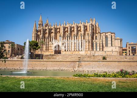 Le côté de la cathédrale de Santa Maria à Palma avec une fontaine et le Palais Royal de la Almudaina Banque D'Images