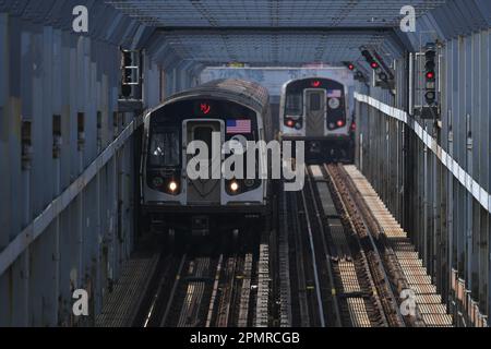 Deux métros traversent le pont de Williamsburg sur 14 avril 2023 à New York. Banque D'Images