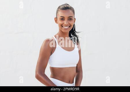 Portrait d'une jeune femme mince en tenue de sport. Belle femme debout dans un studio extérieur. Banque D'Images