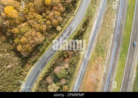 Une vue aérienne d'une longue, droite, et vide autoroute à plusieurs voies, entourée de paysages ruraux Banque D'Images