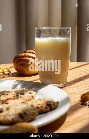 fond de pâtisserie, avec délicieux biscuits aux pépites de chocolat, verre de lait et pain frais, nourriture en studio, boisson Banque D'Images