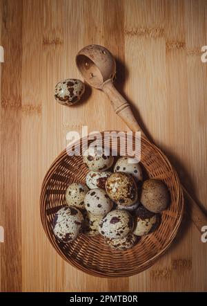 Œufs de caille dans un panier en osier planche à découper en bois fond.nourriture et boisson . Banque D'Images