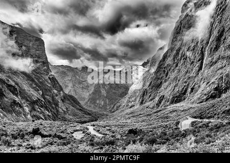 Comparez les conditions météorologiques spectaculaires de la crique de montagne profonde et pittoresque du tunnel Homer dans le son de Milford en Nouvelle-Zélande comme étant noir-blanc. Banque D'Images