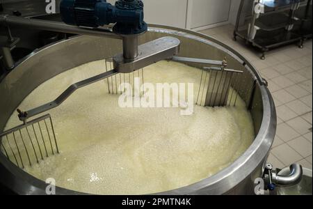 Mélange de caillé et de petit-lait en cuve à l'usine de fromage, vue de dessus. Banque D'Images