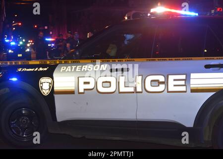 Paterson, États-Unis. 14th avril 2023. Un véhicule de police Paterson bloque la route pour enquêter pleinement sur les lieux du crime. Plusieurs fusillades ont été signalées à Paterson, dans le New Jersey, dans la soirée de vendredi. Deux personnes auraient été abattant sur East 18th Street vendredi soir. Aucun autre renseignement n'a été immédiatement disponible auprès du service de police de Paterson. Crédit : SOPA Images Limited/Alamy Live News Banque D'Images