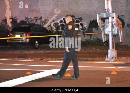 Paterson, États-Unis. 14th avril 2023. Un agent marche à côté des marqueurs de preuve placés sur la scène du crime. Plusieurs fusillades ont été signalées à Paterson, dans le New Jersey, dans la soirée de vendredi. Deux personnes auraient été abattant sur East 18th Street vendredi soir. Aucun autre renseignement n'a été immédiatement disponible auprès du service de police de Paterson. Crédit : SOPA Images Limited/Alamy Live News Banque D'Images