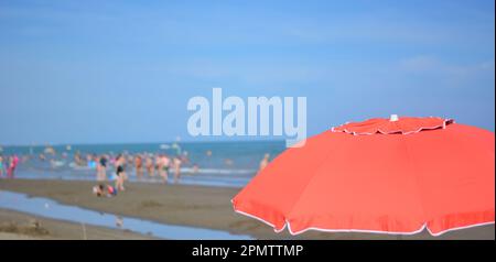 un parasol rouge ouvert en face de la mer Banque D'Images