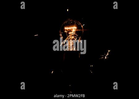 Lumière et étincelles provenant d'une lampe à incandescence qui brûle. Court-circuit Banque D'Images