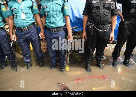 La police du Bangladesh et le personnel du bataillon d'action rapide (RAB) ont été vus debout sur une route submergée lors de l'accident d'incendie sur le marché de l'habillement à Dhaka. Un grand incendie a ravagé des milliers de magasins sur un marché populaire de l'habillement dans la capitale bangladaise, Dhaka, où les propriétaires de magasins ont été dévastés par les pertes des semaines précédant l'Eid, le festival musulman marquant la fin du Ramadan. Des centaines de pompiers et de militaires ont lutté contre l'inferno alors qu'il a déchiré le marché de l'habillement, en le transformant en une pile de cendres. Plusieurs personnes ont été blessées, mais aucun décès n'a été signalé jusqu'à présent. Les autorités l'étaient encore Banque D'Images