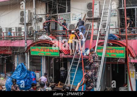 Dhaka, Bangladesh. 15th avril 2023. Les trois services militaires en uniforme du pays, l'armée de terre, la marine, l'armée de l'air et le bataillon d'action rapide, aident à éteindre un incendie au Nouveau supermarché de Dhaka. Un coup de feu massif a éviscéré les magasins du nouveau supermarché de Dhaka, l'un des plus grands marchés de l'habillement du pays, devant Eid-ul-Fitr. Des membres du personnel d'urgence de l'Armée de terre, de la Force aérienne, du bataillon d'action rapide, de la police du Bangladesh et des gardes-frontières du Bangladesh ont Uni leurs forces avec 28 unités du Service des incendies et de la Défense civile pour essayer de maîtriser les flammes samedi. Crédit : SOPA Images Limited/Alamy Live News Banque D'Images