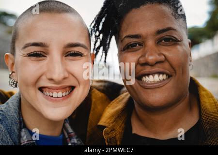 Portrait d'amis multiraciaux heureux regardant l'appareil photo à l'extérieur - authentiques personnes diverses - foyer principal sur le nez de la femme afro-américaine Banque D'Images