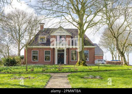 Dorwerd, pays-Bas - 27 mars 2023: Maison pittoresque avec arbres dans le village de Littel Dorkwerd municipalité de Groningen aux pays-Bas Banque D'Images