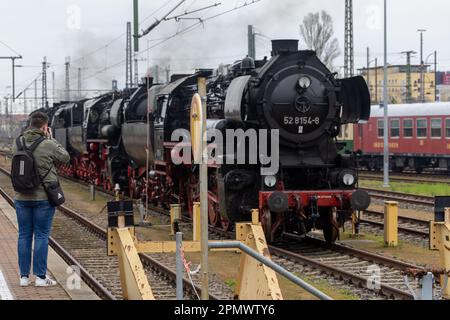 Dresde, Allemagne. 15th avril 2023. Un homme prend une photo de la locomotive 52 8154-8 qui se tient sur la piste lors de la réunion de la locomotive à vapeur de Dresde en 15th à l'occasion du 125th anniversaire de la gare centrale de Dresde. Les fans de train se réunissent ces jours-ci avec des trains historiques et célèbrent la technologie et l'expérience du voyage ferroviaire. Credit: Daniel Schäfer/dpa/Alay Live News Banque D'Images