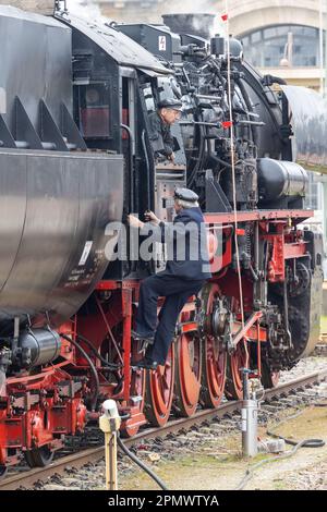 Dresde, Allemagne. 15th avril 2023. Un homme monte à bord de la locomotive 528154-8, qui est garée sur une voie à l'extérieur de l'édifice de la gare. Les fans de train avec des trains historiques se rassemblent pour la réunion des locomotives à vapeur de Dresde en 15th à l'occasion du 125th anniversaire de la gare centrale de Dresde. Credit: Daniel Schäfer/dpa/Alay Live News Banque D'Images