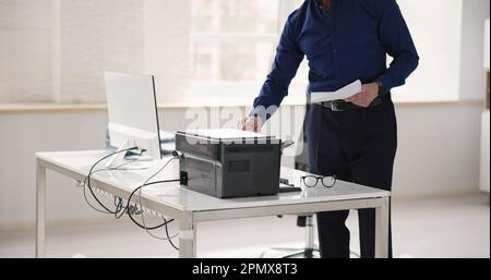 Homme utilisant une machine à photocopier dans Office. Imprimante et copieur Banque D'Images