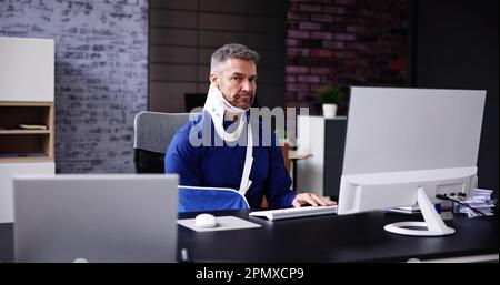 Accident : rupture du bras. Homme au bureau utilisant un ordinateur Banque D'Images