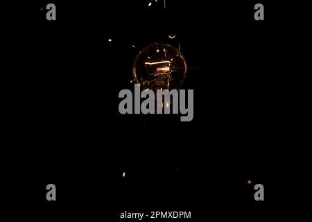 Lumière et étincelles provenant d'une lampe à incandescence qui brûle. Court-circuit Banque D'Images