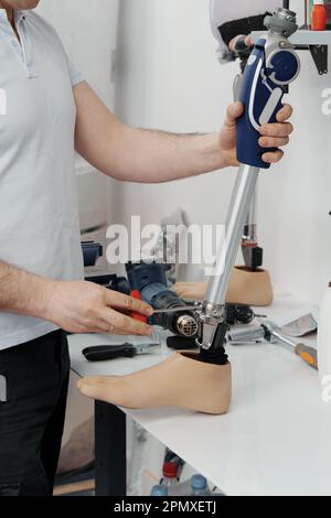 Récolte d'artisan méconnaissable ajustement et flexion de la jambe prothétique moderne à la section du genou Banque D'Images