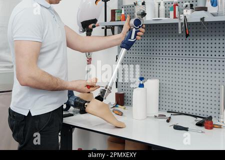 Récolte d'artisan méconnaissable ajustement et flexion de la jambe prothétique moderne à la section du genou Banque D'Images