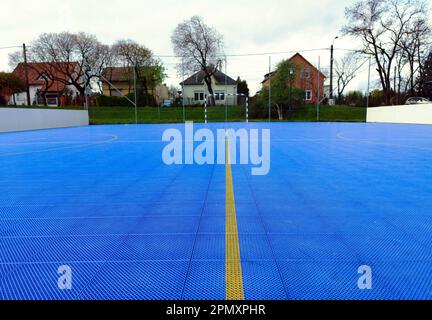 petit terrain de football extérieur avec plancher de sport en vinyle bleu. carreaux de verrouillage. sol moderne de loisirs et de piste. séparateur de champ de ligne de peinture jaune Banque D'Images