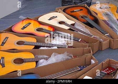 De nombreux nouveaux instruments de musique de guitares acoustiques dans des boîtes à vendre Banque D'Images