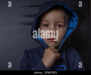 Un jeune enfant aux yeux avariés souffre de conjonctivite.gros plan d'un oeil de sang sévère.Londres Angleterre Banque D'Images