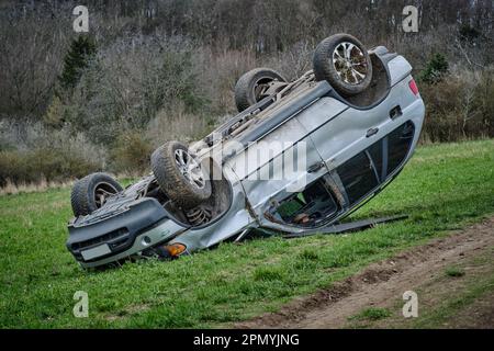 Gros vus après un capotage sur le toit dans la nature. Accident de voiture dans un champ agricole. Accident sur route rurale poussiéreuse. Isolé, déformé écrasé renversé Banque D'Images