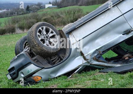 Gros vus après un capotage sur le toit dans la nature. Accident de voiture dans un champ agricole. Accident sur route rurale poussiéreuse. Isolé, déformé écrasé renversé Banque D'Images