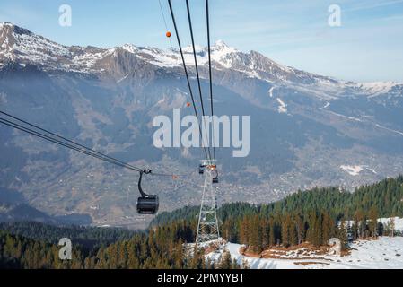 Télécabine se déplaçant au-dessus de la forêt contre de belles montagnes bernoises Banque D'Images