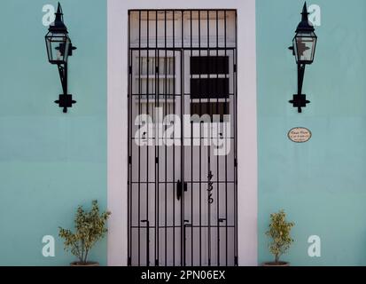 Un bâtiment vert avec une porte et des sconces à Merida, Yucatan, Mexique. Banque D'Images